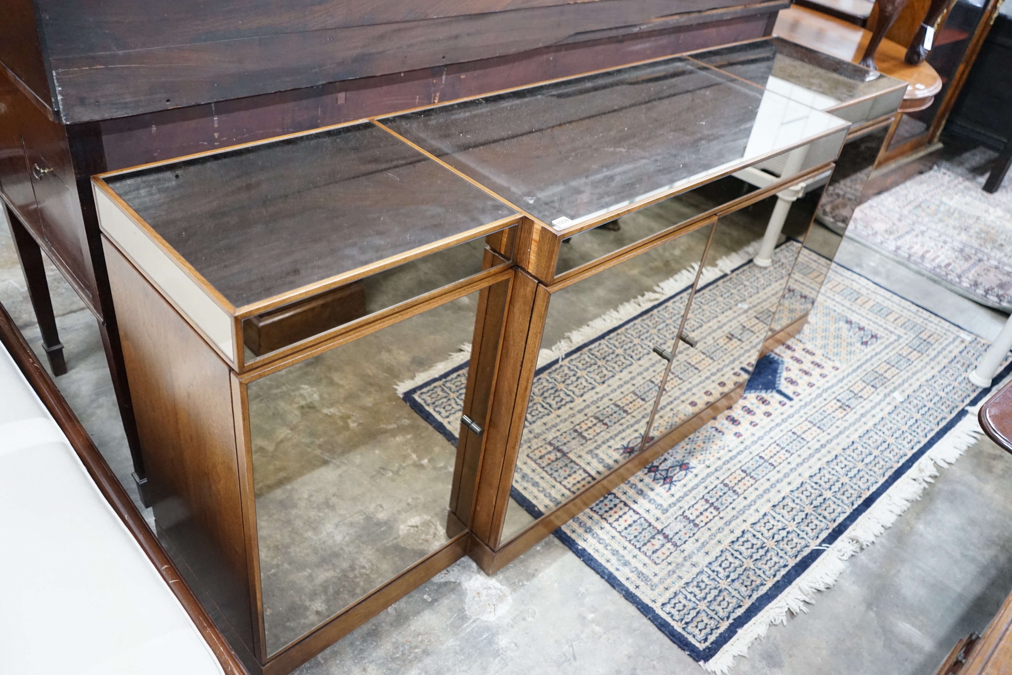 A contemporary mirrored walnut breakfront four door sideboard, width 200cms, depth 50cms, height 86cms.